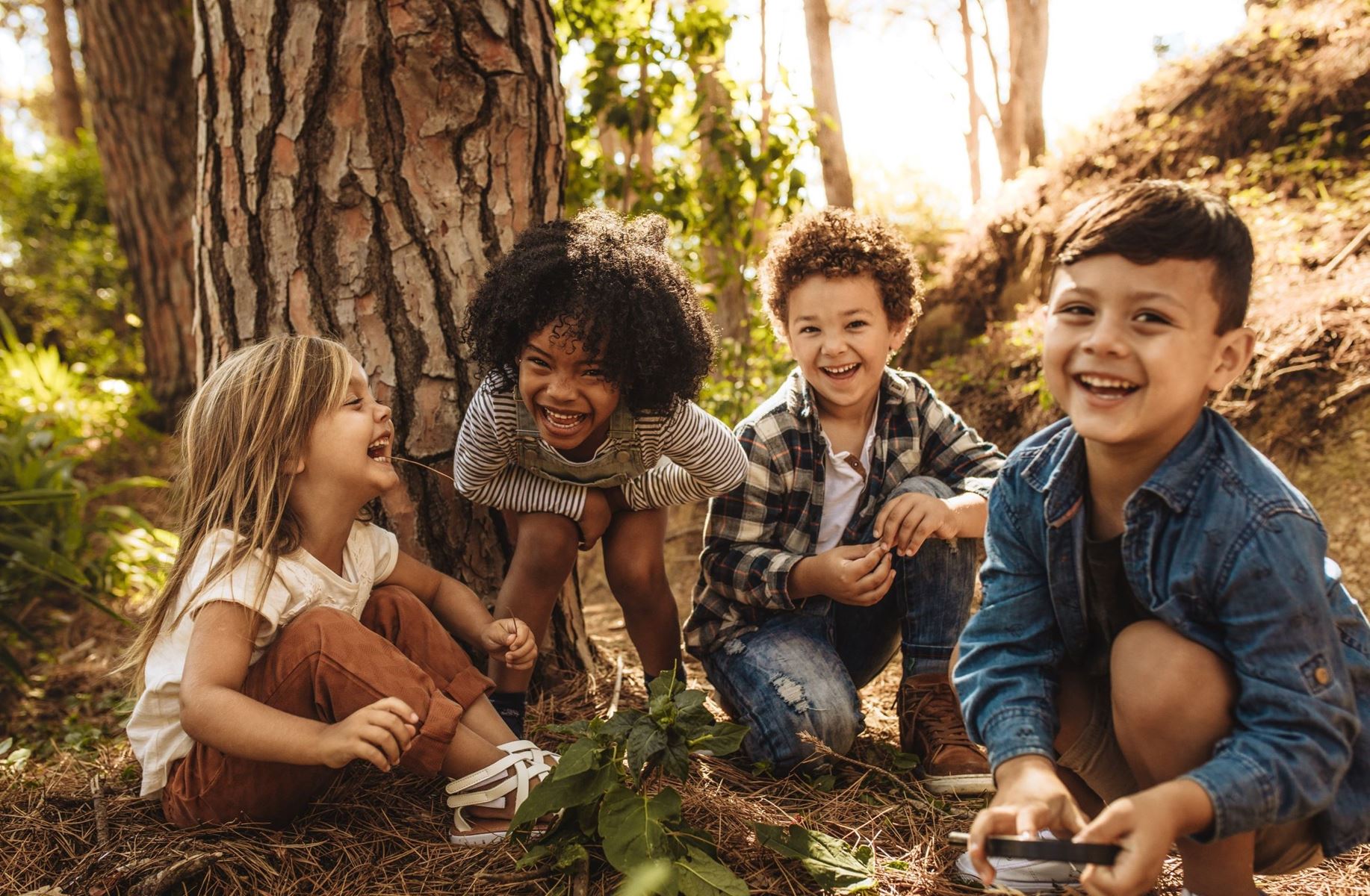 kids sitting and laughing in front of a tree